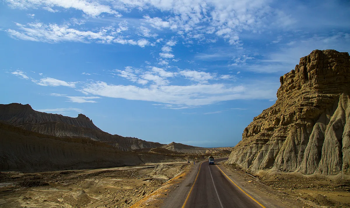 The Makran Coastal Highway curving between eroded desert cliffs in Balochistan