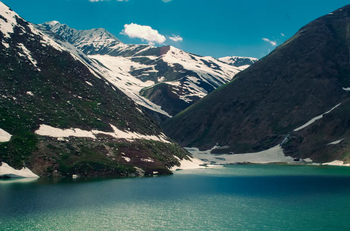 Deep green water of Lulusar Lake beneath snow-streaked slopes in the Kaghan Valley